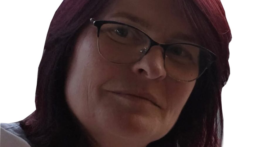A woman with shoulder-length dark red hair, wearing glasses and a white top, is looking at the camera with a neutral expression. The background is white.